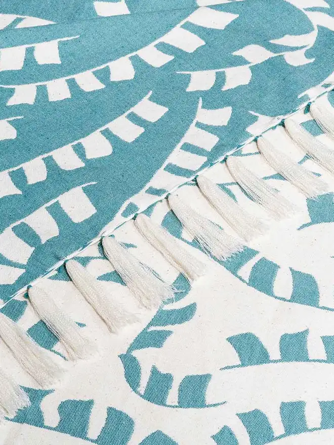 Teal Prayer Flag Woven Throw, a blue throw set on a plain white surface. 