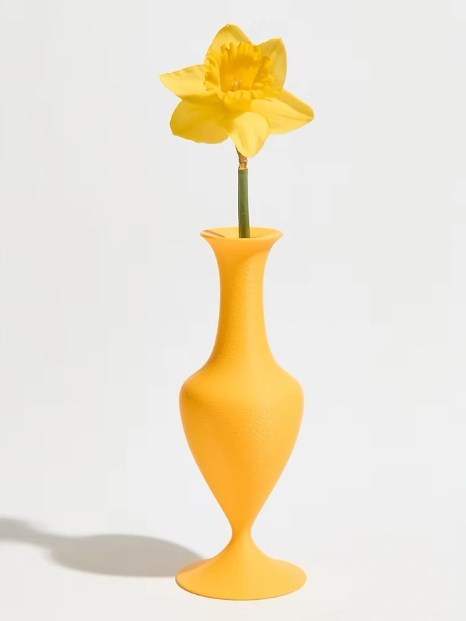 curve shaped yellow 3d printed vase with yellow flower