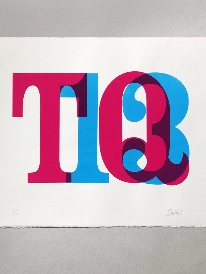 A flat lay of a print of big postcode letters and numbers screenprinted in magenta and cyan ink overlapping somewhat, with the overlap colour showing as purple. 