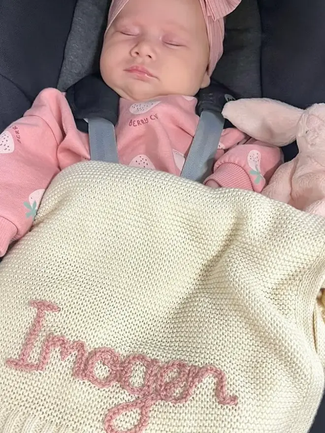 Hand Embroidered Baby Blankets, a hand embroidered blanket sitting on a baby. 