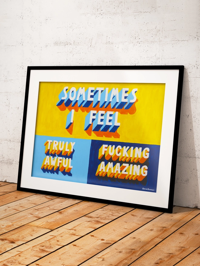 Framed typographic art print leaning against a white textured wall on a wooden floor. The artwork features bold 3D-style lettering in blue, yellow and orange with orange and blue shadows on a bright yellow and blues background. The text reads “SOMETIMES I FEEL TRULY AWFUL / FUCKING AMAZING” in uppercase letters. Signed "Survival Techniques" in the bottom right corner.
