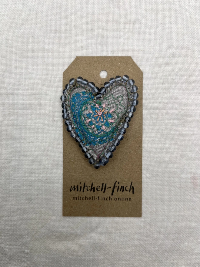 blue beaded brooch on label