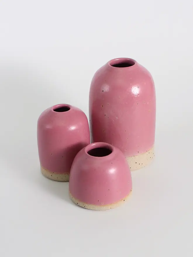 Cluster of our fuchsia ceramic vases in mini, small and medium sizes against a white background.