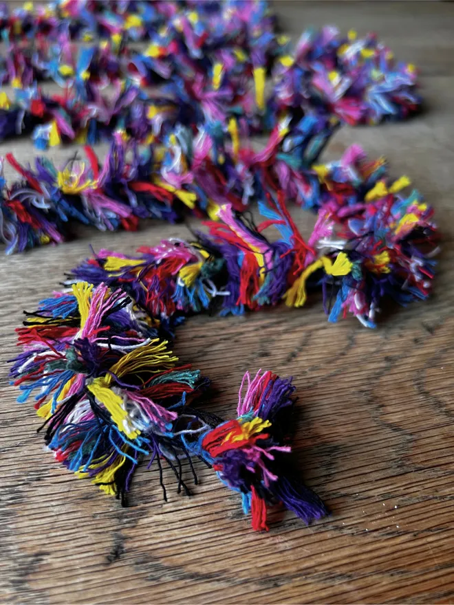 Close up image of Rainbow Strinsel string tinsel on an oak table top