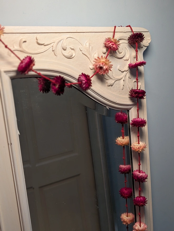 Garland of pink flowers 0n a mirror 