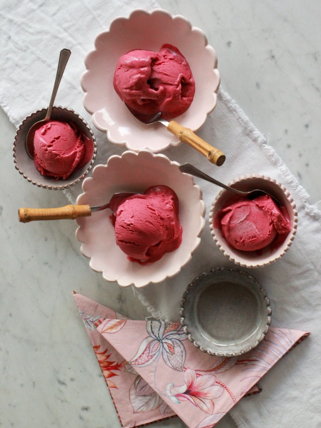 light pink ice cream bowls with bamboo spoons and damson sorbet