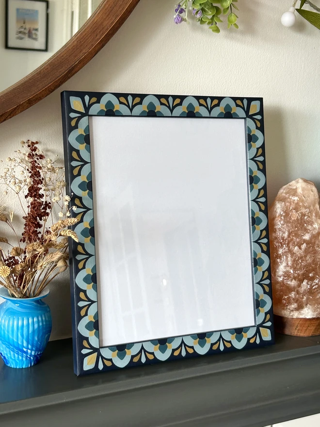 Heavily patterned medium sized picture frame hand painted in shades of blue with gold details