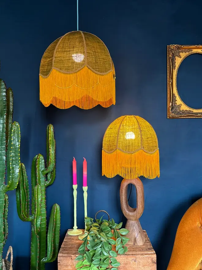 Fringed Hessian Lampshade In Pickle Green And Antique Gold, in a room. 