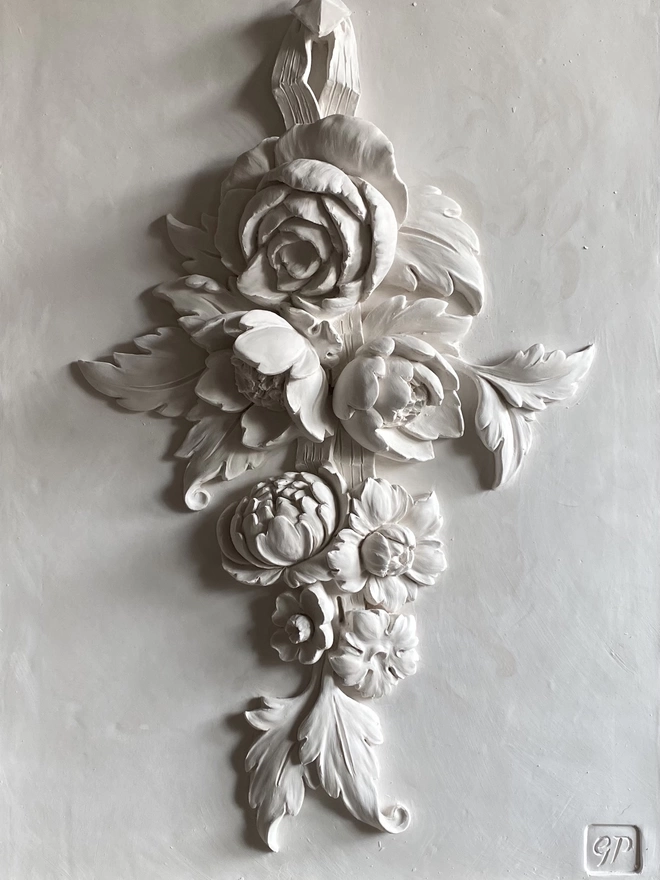 Detail of white plaster wall sculpture with flower design 