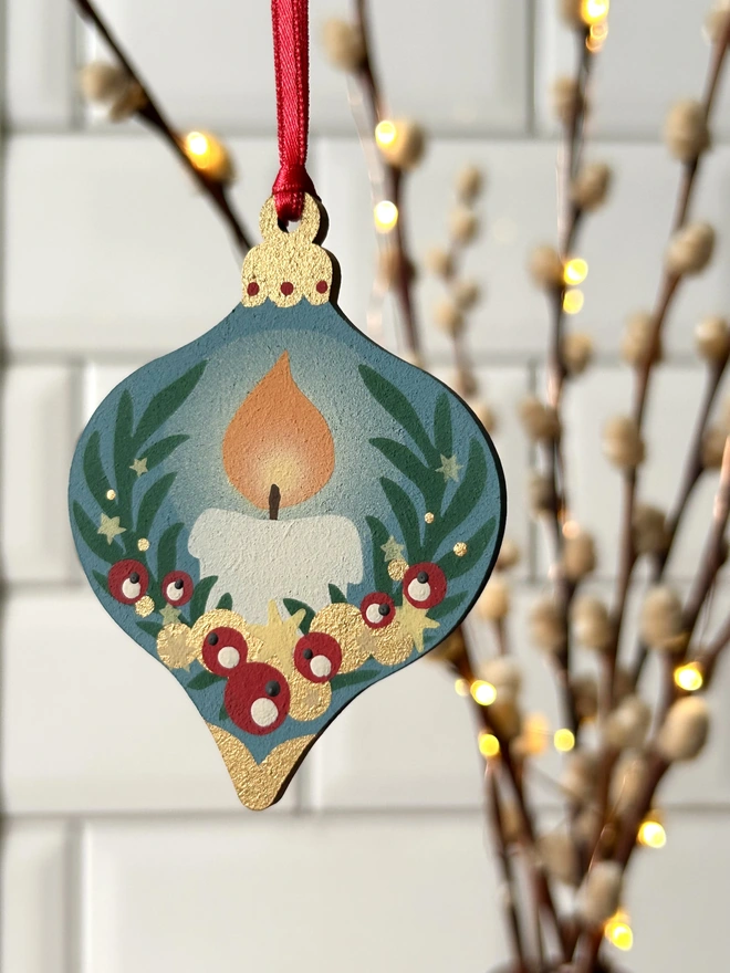 Laser cut wooden bauble shapes which have been hand painted with one christmas candle design and one with a festive bell design. Using blue, yellow, green, red and gold paint.