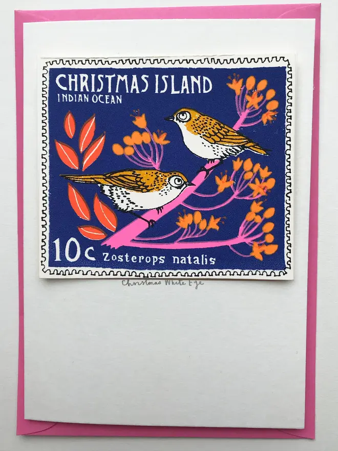 Bird Stamp Card Christmas Island White Eye Stamp , a Christmas card with a pair of birds stamp on a white surface with a pink envelope in the background. 