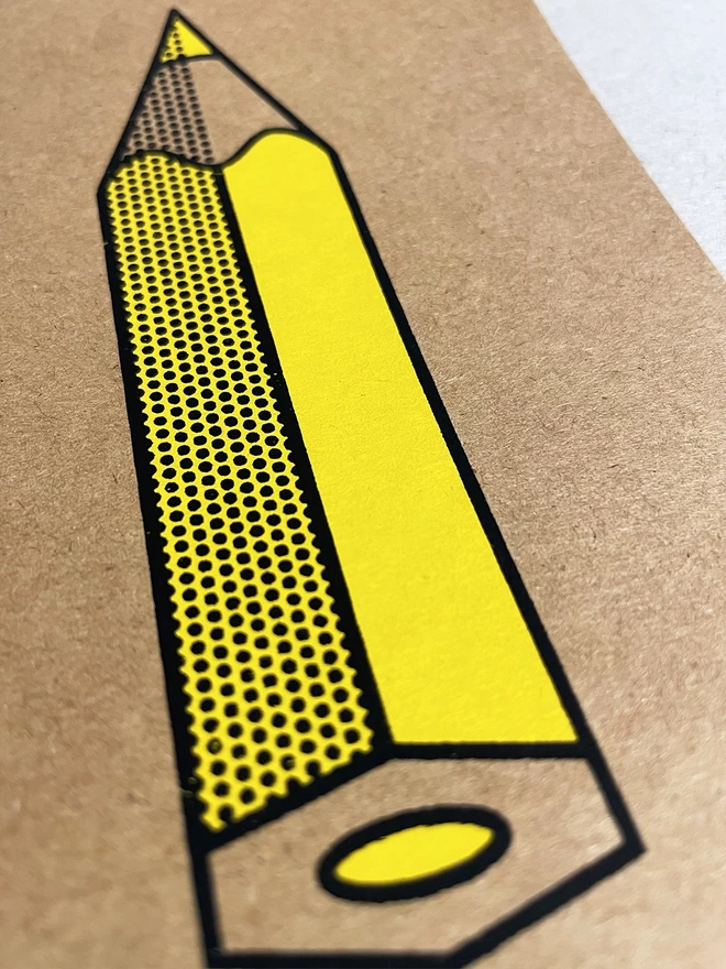 Close up detail of the yellow pencil screenprinted card. Bright yellow body of the pencil with black outline and halftone detailing. The pencil is pointing to the top of the frame, slightly away from the camera.
