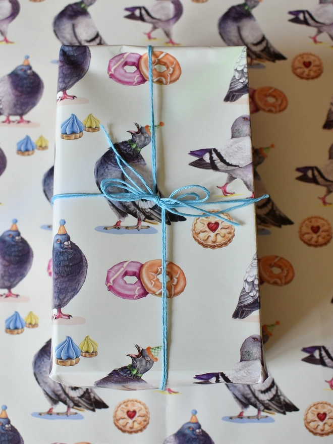 a gift wrapped in paper featuring hand illustrated pigeons and biscuits