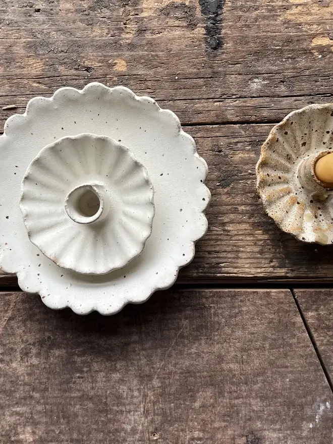 Handmade Scalloped Ceramic Dish, a pair of ceramic dishes on a wooden surface. They are accompanied by some candles. 