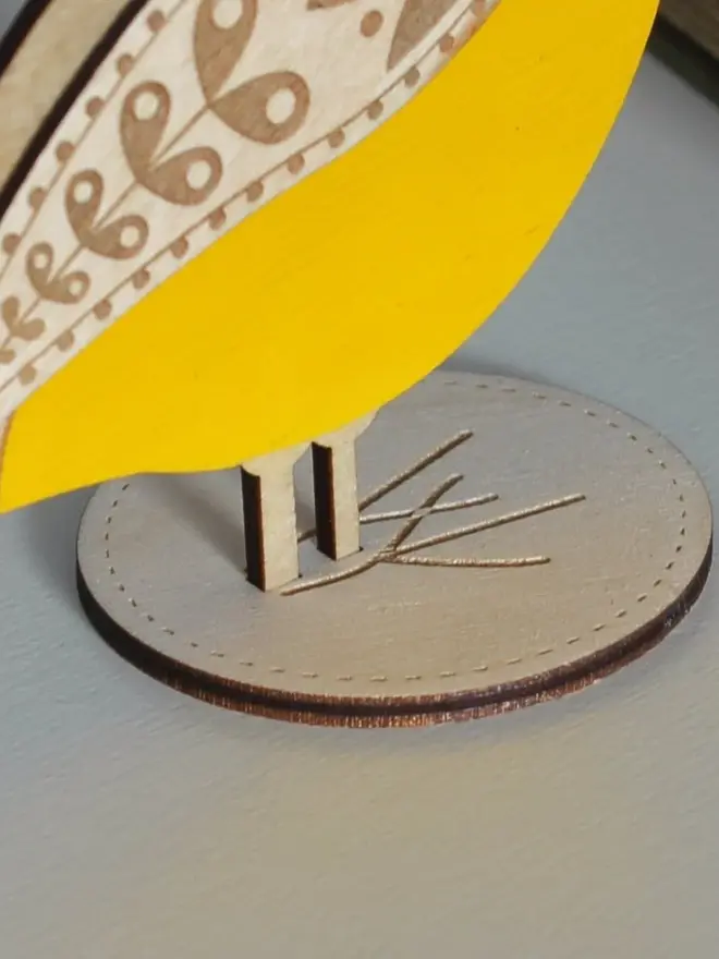 Standing Wooden Blue Tit, yellow wooden bird decoration standing on a platform. 