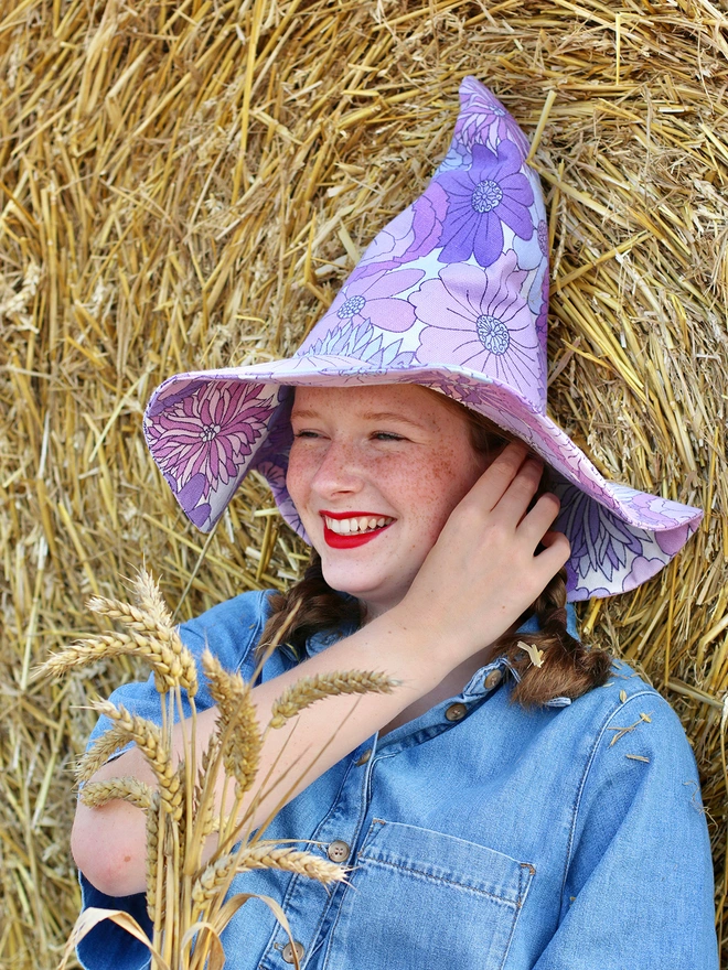 Smiling witch wearing a handmade and upcycled sustainable witch hat