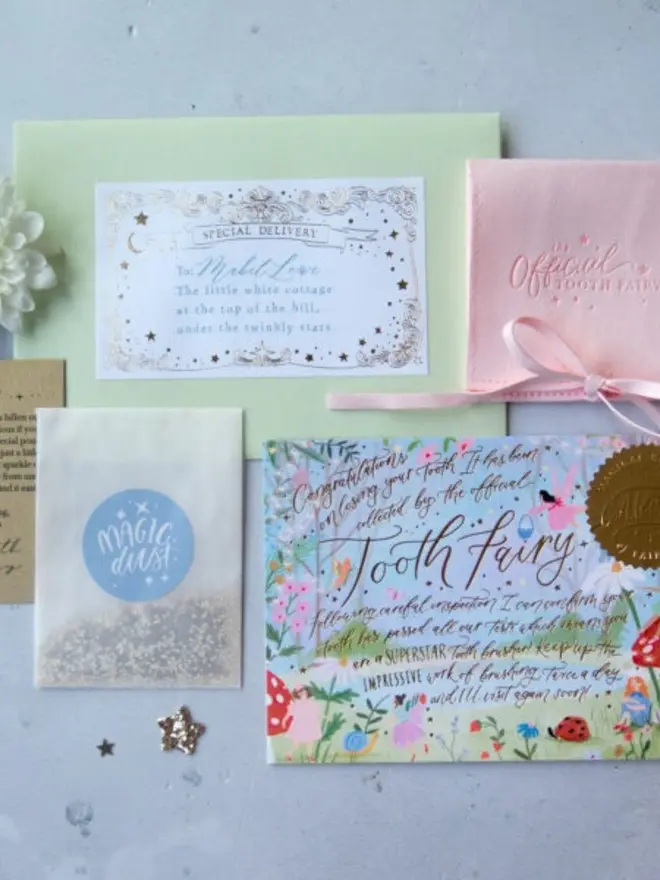 A pale green envelope with a gold foil "Special Delivery" label is addressed to Mabel Love. It's laid out with a blush pink pouch, a Magic Dust packet and the garden notecard.