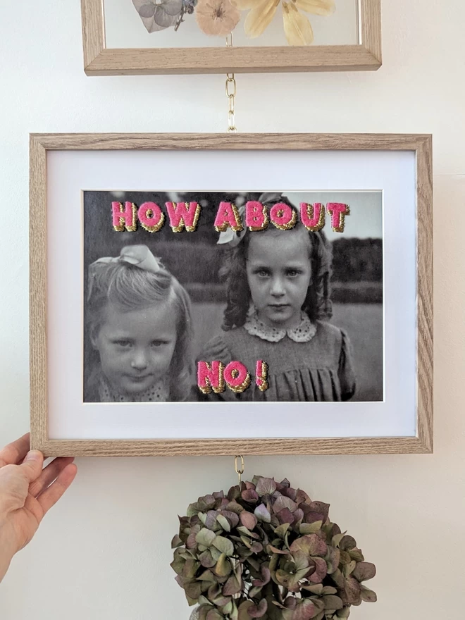 B&W photo print of 2 girls with embroidered pink and Gold lettering, How about No! in frame