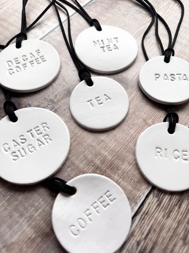 Minimalist white leather pantry tags with hand-stamped labels for kitchen storage. Rustic and stylish labels with black cord, ideal for home organisation and pantry décor.