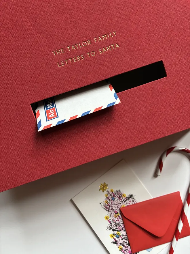 Handmade Christmas postbox in traditional pillar box red cloth with gold foiled lettering and airmail envelope