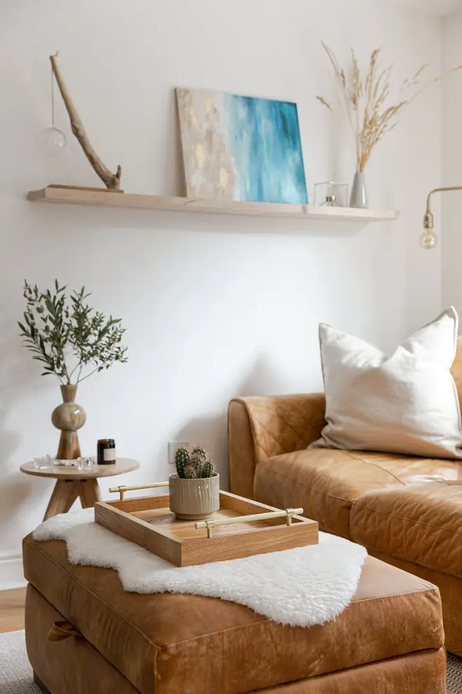 Oak and Brass Serving Tray, a wooden serving tray sat on a sofa accompanied by some plants against a plain backdrop.  