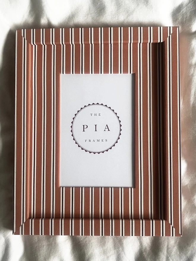 Tangerine & Burgundy Seaside Stripe Frame, a colourful striped frame sitting on a plain white surface. 