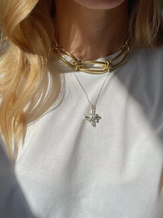 bold 18 carat gold chain collar worn with a silver equal armed peaceful cross pendant