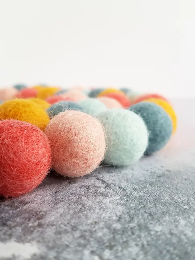 A pastel rainbow felt ball garland.