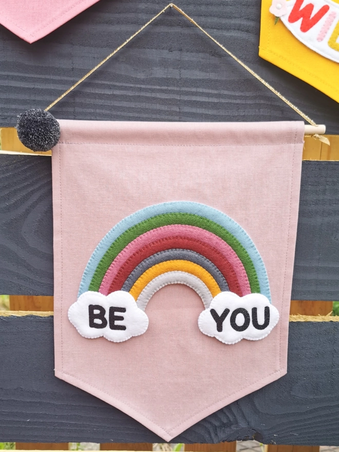 Lilac be you banner hanging in a garden on a fence