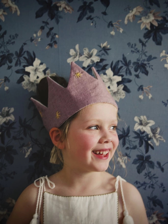 Little girl in her lilac dressing up crown