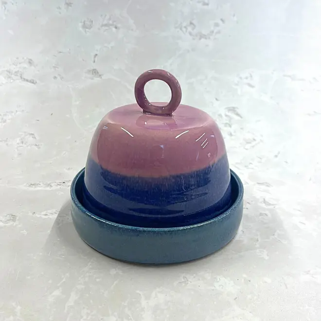 Landscape Butter Dish, a colourful butter dish sitting on a stone surface. In the image the lid sits on top of the dish. 