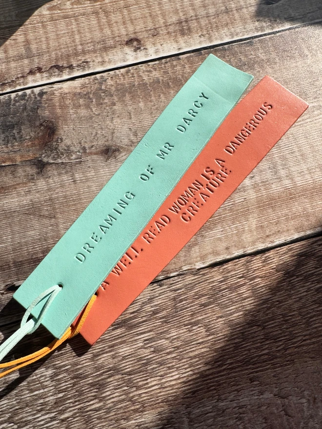 Colourful hand-painted leather bookmarks with embossed quotes, each featuring a leather tie. A stylish and durable accessory for book lovers, perfect as a personalised gift