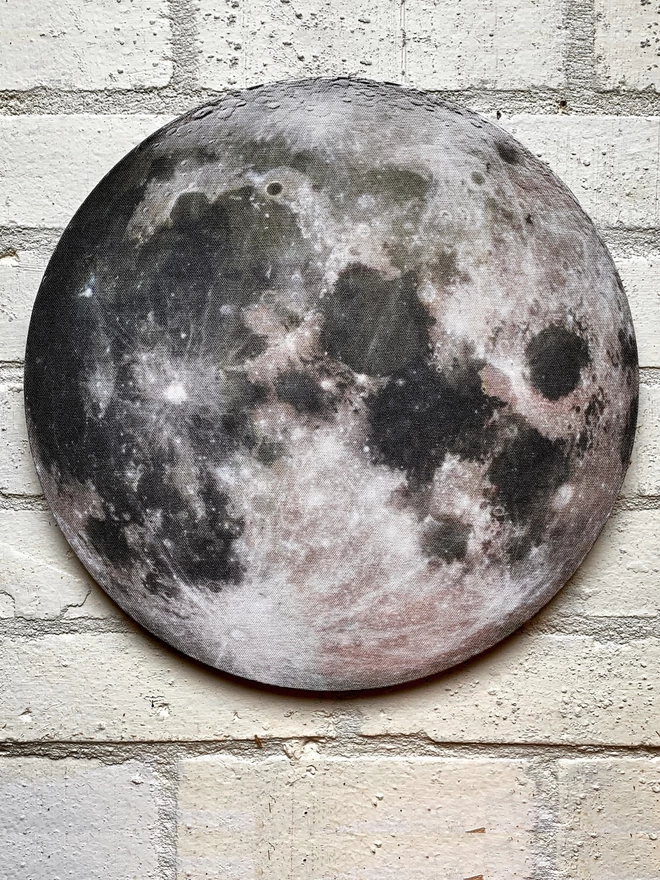 Moon wall art on a white painted brick wall