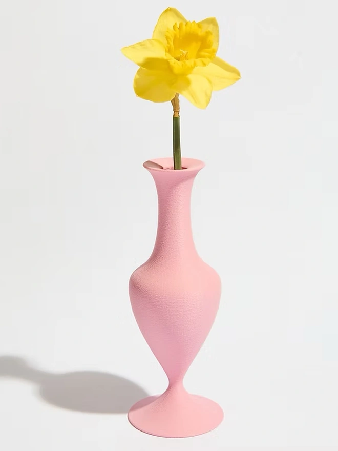 pink 3d printed vase in curve shape with yellow flower