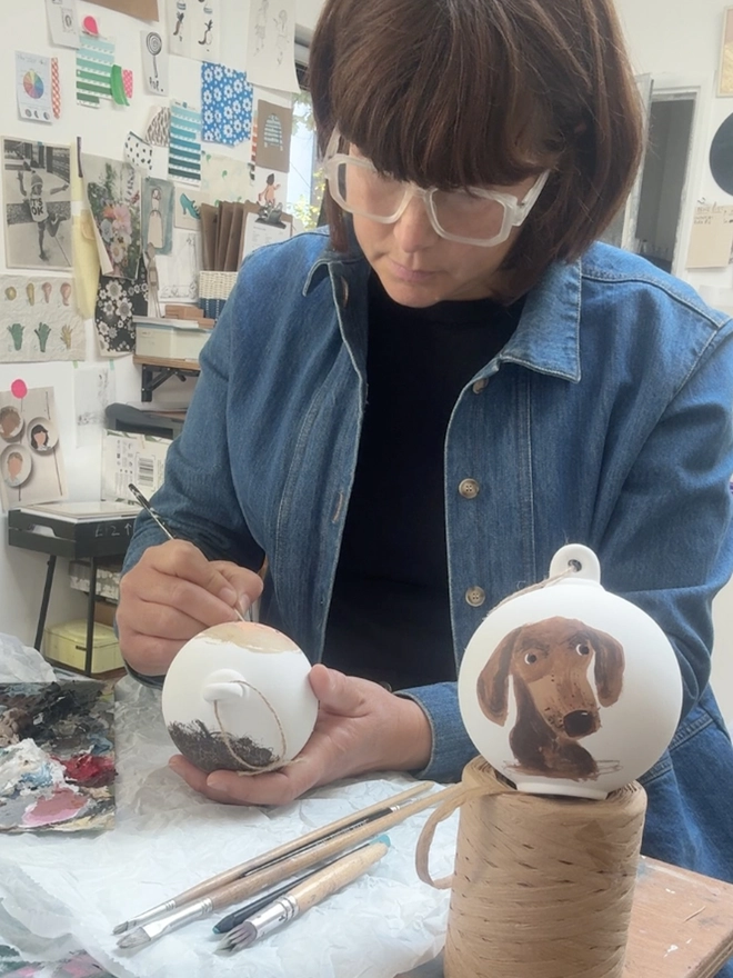 artist in studio painting bauble