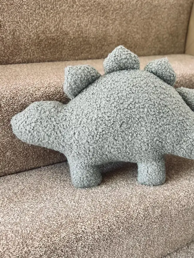boucle dinosaur pillows. a grey stegosaurus cushion.