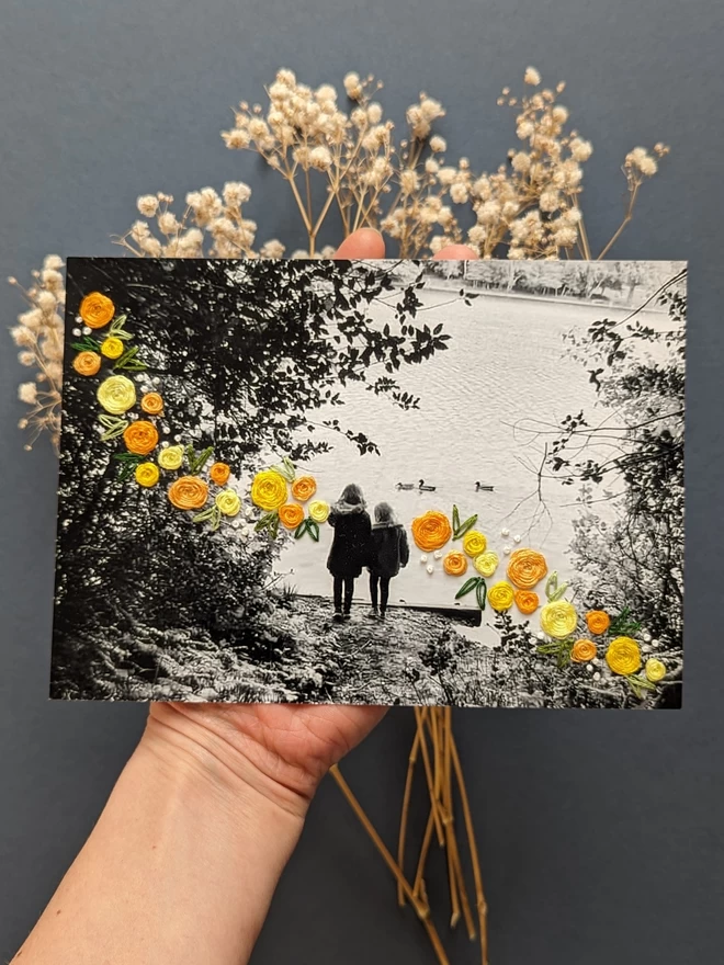 B&W photo of 2 girls with yellow flowers embroidered around them