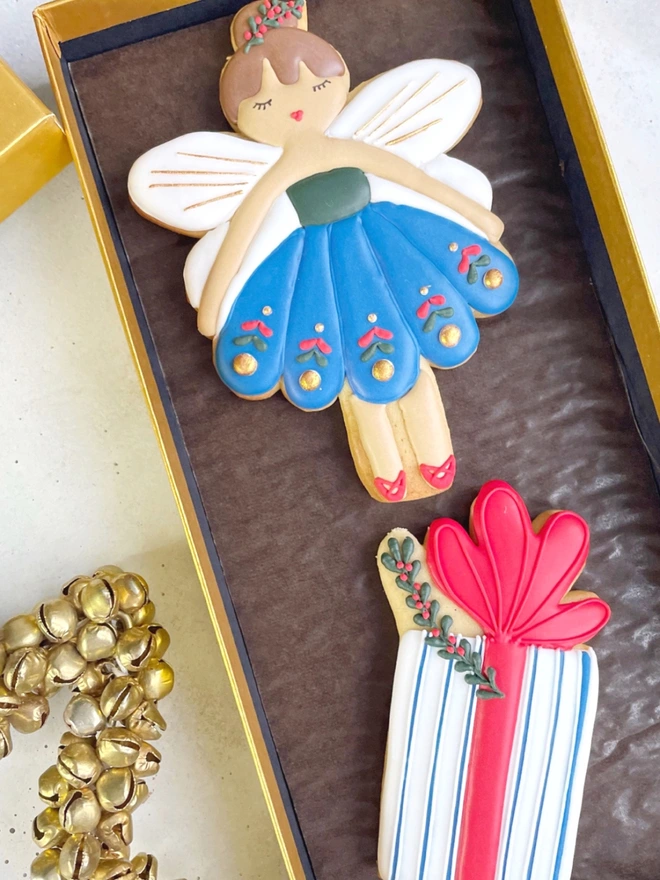 Hand-iced Christmas biscuits featuring a Nutcracker and a present in a festive gift box, available in Vanilla or Gingerbread flavour