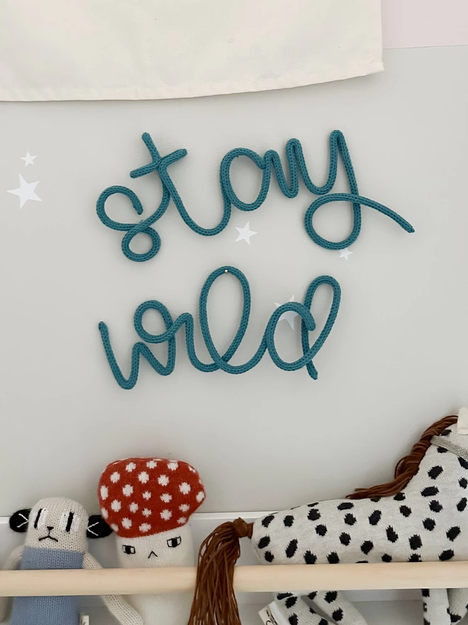 "stay wild" wall sign hanging up on the wall in a kids' room. 