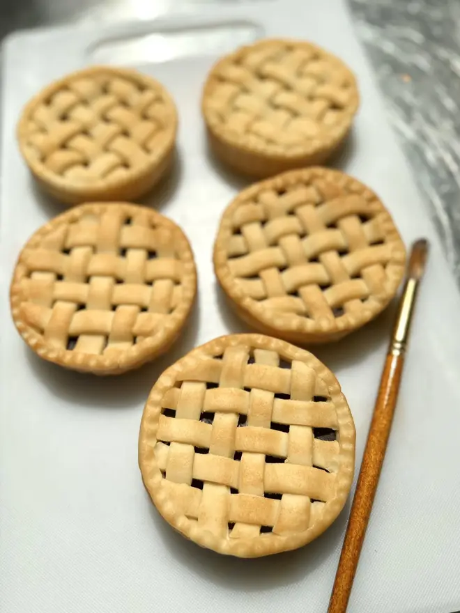 Marzipan Cherry Pie, a group of marzipan cherry pies on a table surface. 