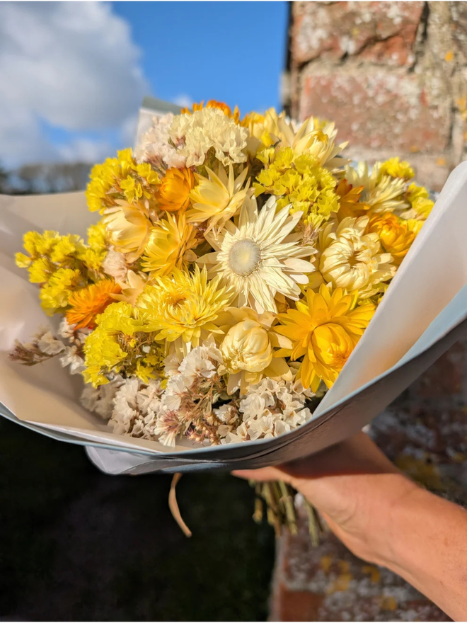 golden sunshine dried flower bouquet. bouquet of dried yellow flowers tied in a bunch
