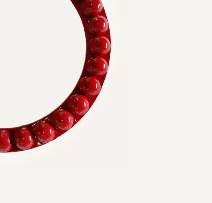 Round oversized bobbin mirror with a decorative bobbin-style wooden frame, hanging on a white wall.