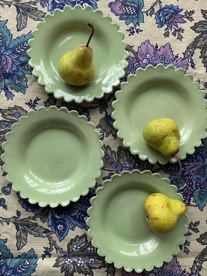 sage green shallow bowls with pears on a liberty print background