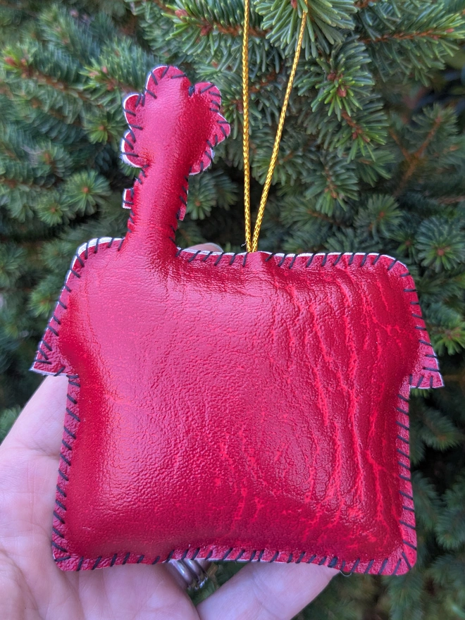 Hand stitched personalised Christmas house decoration made from vegan-friendly faux leather, featuring a red roof, gold stars and a family name banner.