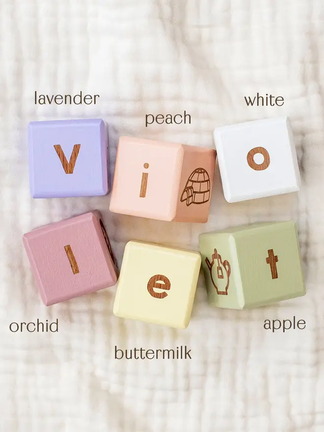 wooden baby letter blocks. a selection of square wooden blocks with engraved letters and illustrations, in various colours. 