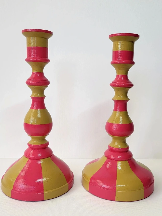pair of wooden candle stick holders, hand painted in pink and mustard yellow stripes