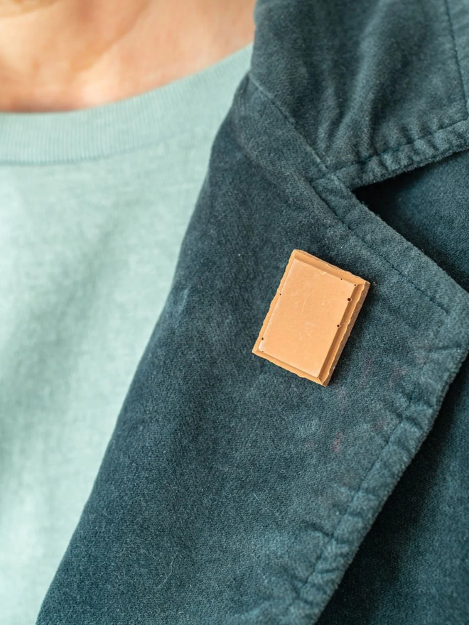 chocolate pin badges. a milk chocolate badge on a coat lapel.