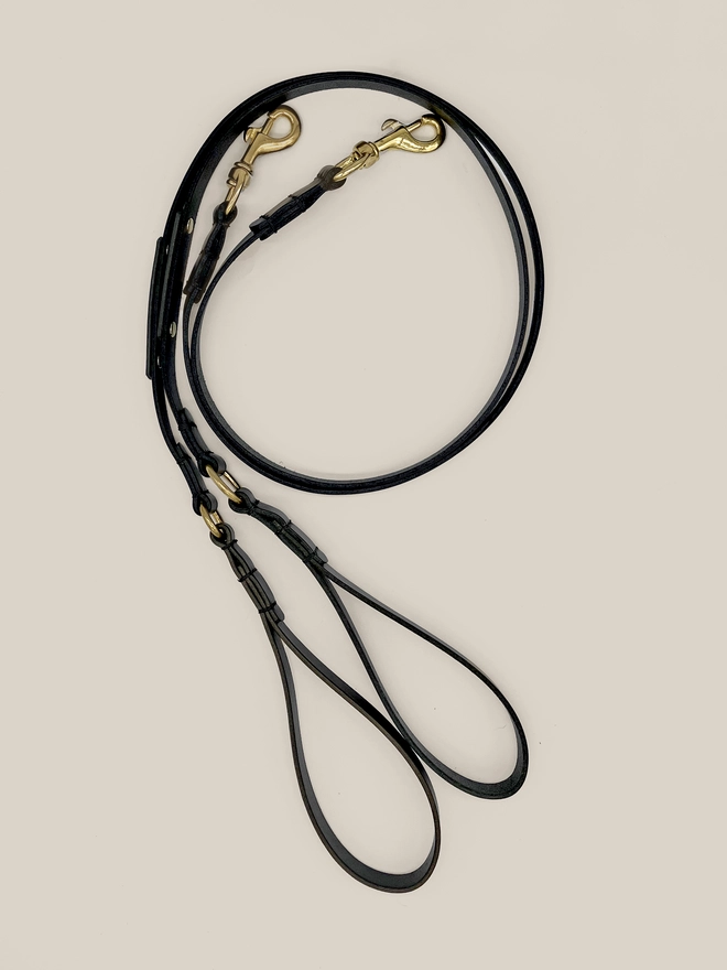 2 black leather dog leads curled up