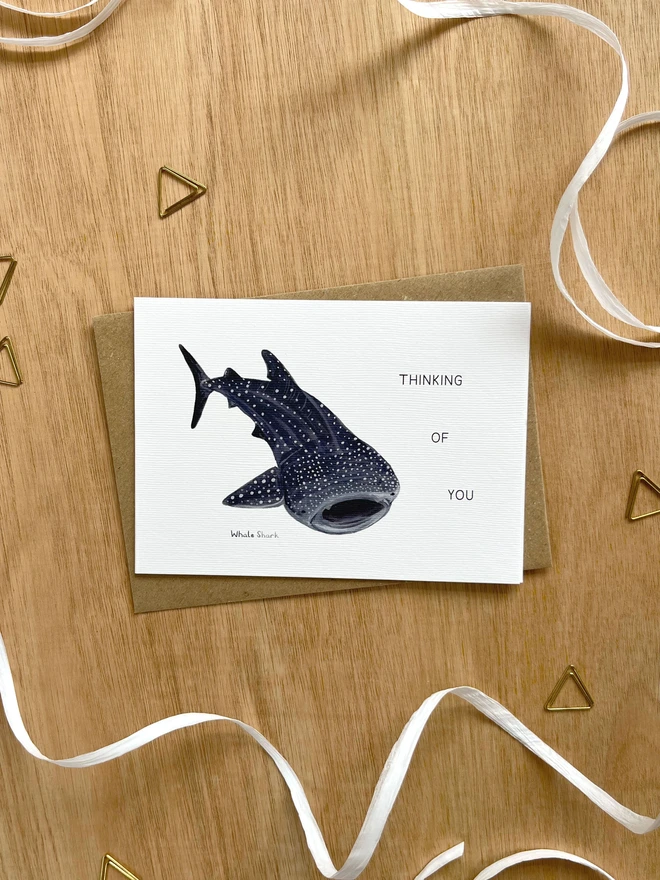 a greetings card featuring an illustration of a whale shark with the text “Thinking of you”