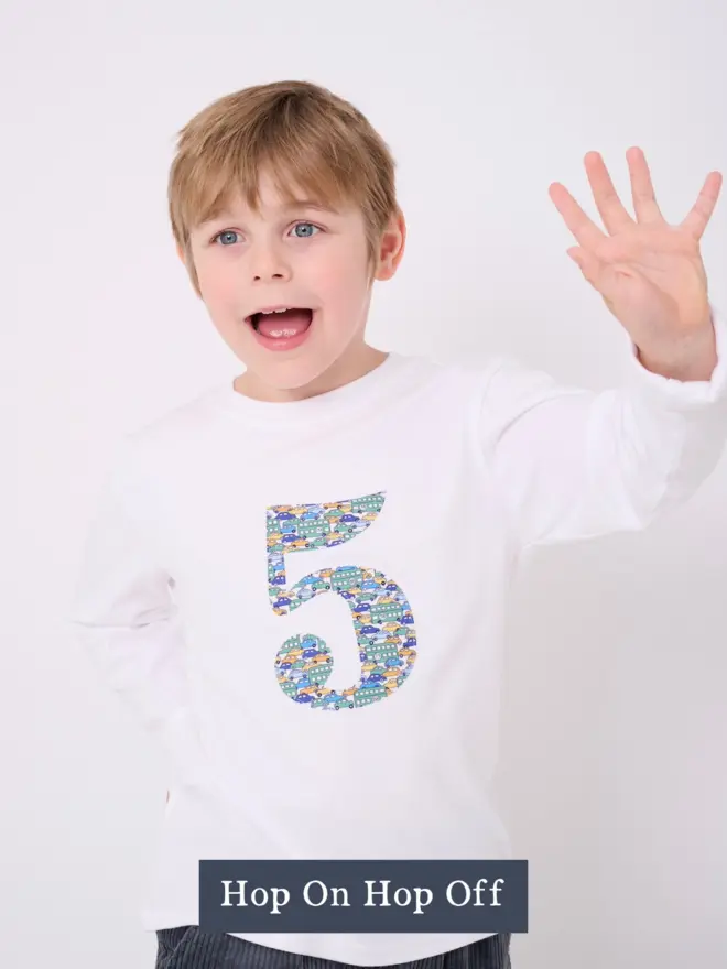 a little boy wearing a white birthday t-shirt with a number 5 cut from liberty hop on hop off print on the front